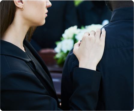 a couple grieving by a casket