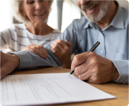 An older gentleman signing a document